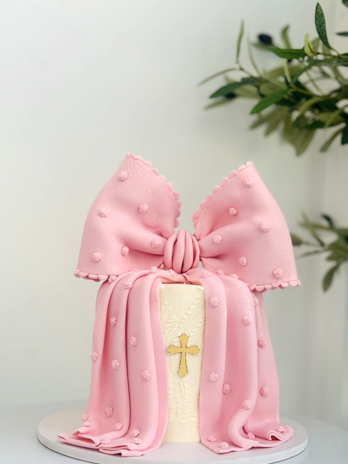 Soft pink bow cake with gold cross detail